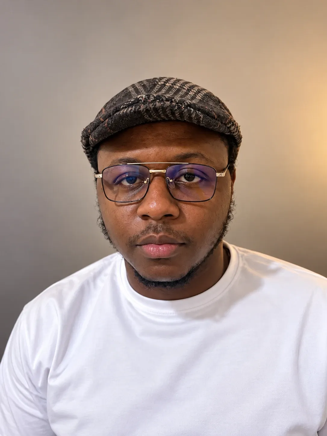 Rian Ndam, fondateur d'Orvelai : portrait de face, casquette et lunettes, sur fond clair.